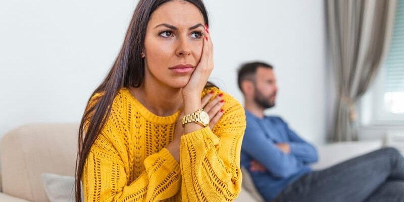 Frustrated couple not speaking to each other sitting on sofa