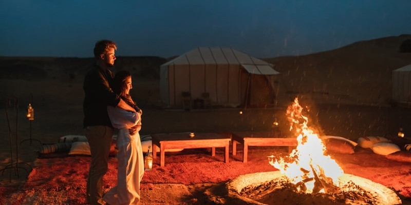 Couple hug in love near big campfire
