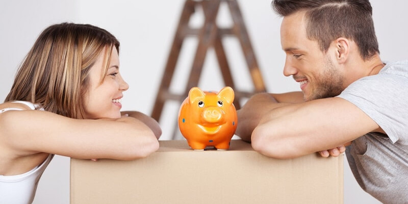 Happy couple looking at the piggybank