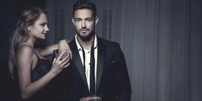 man in suit with his girlfriend drinking wine