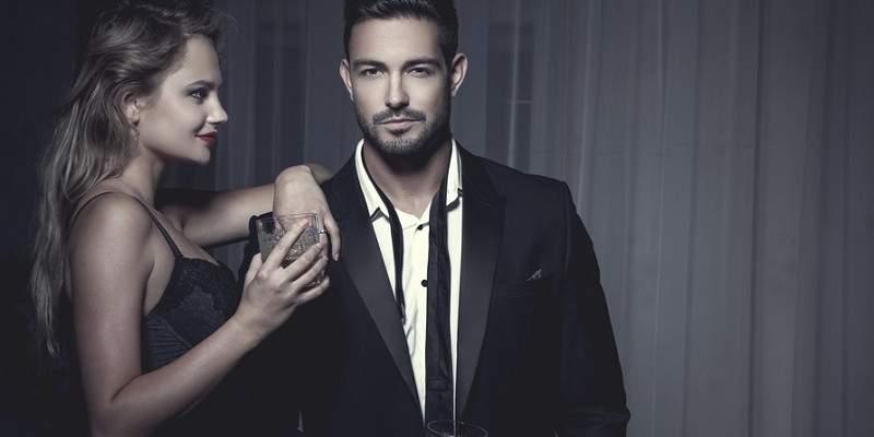 Well dressed couple with glass of whiskey