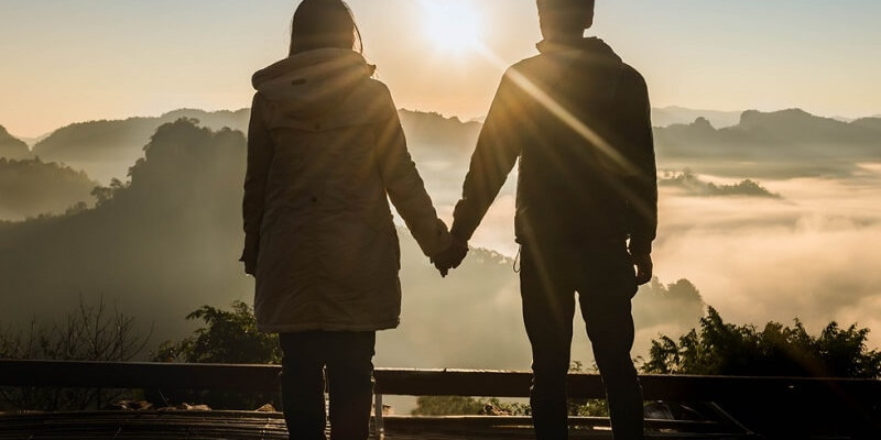 silhouette couple holding hands looking in the Sun rise