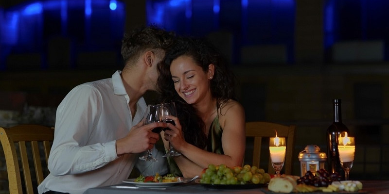 happy married couple in love drinking wine at romantic date and flirting