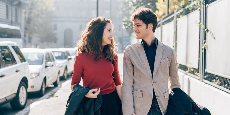 Young beautiful couple in love chatting walking outdoor in the city
