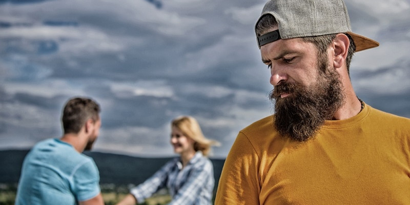 Man feeling lonely couple dating behind him
